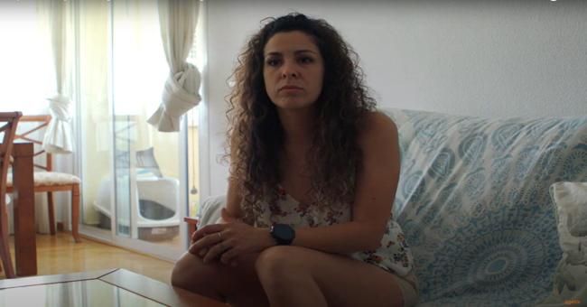 Mujer sentada en un sofá en una sala de estar.