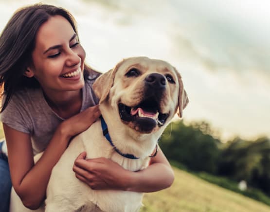 Sonriente dueña de mascota con un perro feliz